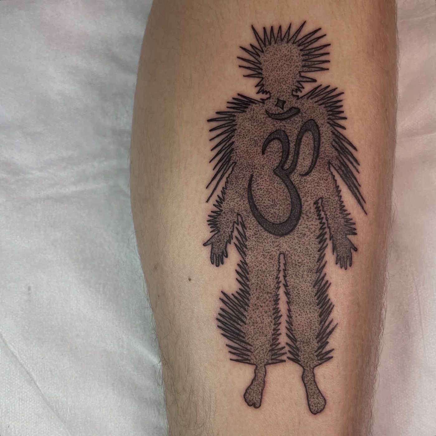 Dotwork leg tattoo of a spurred figure with a horseshoe ring inside a radiating silhouette